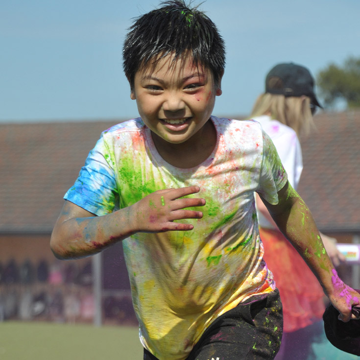Student running through colour fun run at Our Lady of the Rosary Catholic Primary School St Marys
